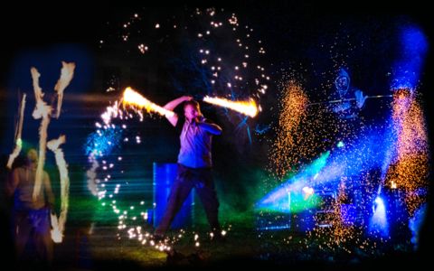 3 Feuerkuenstler bei einer Feuershow mit Funkeneffekten, brennenden Seilen und Fackeljonglage